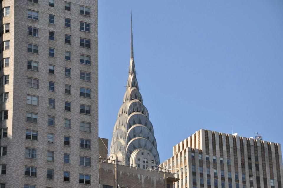 Apparition furtive de la flèche du Chrysler building au-dessus d'un buildin
