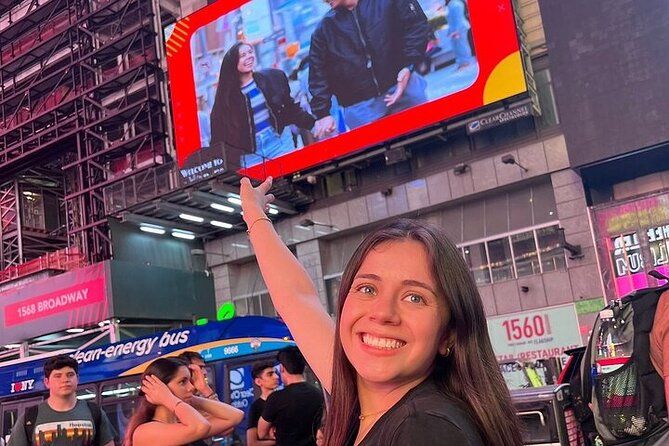 Jeune fille posant devant l'écran géant de Times Square à New York