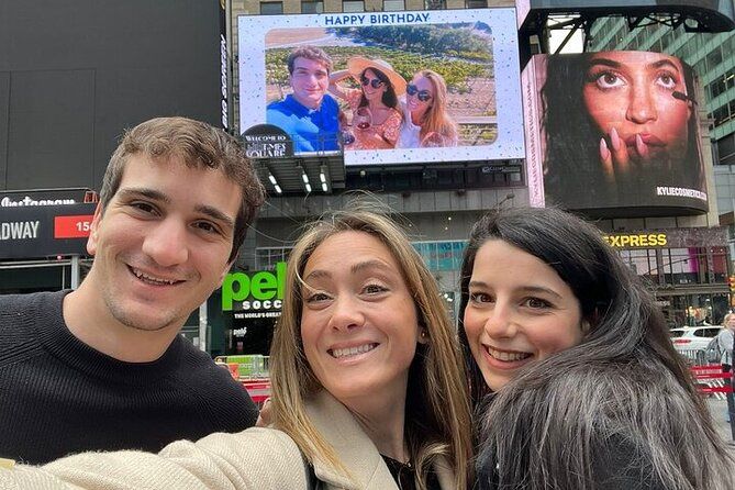 Groupe d'amis en photo devant un écran géant sur Times Square