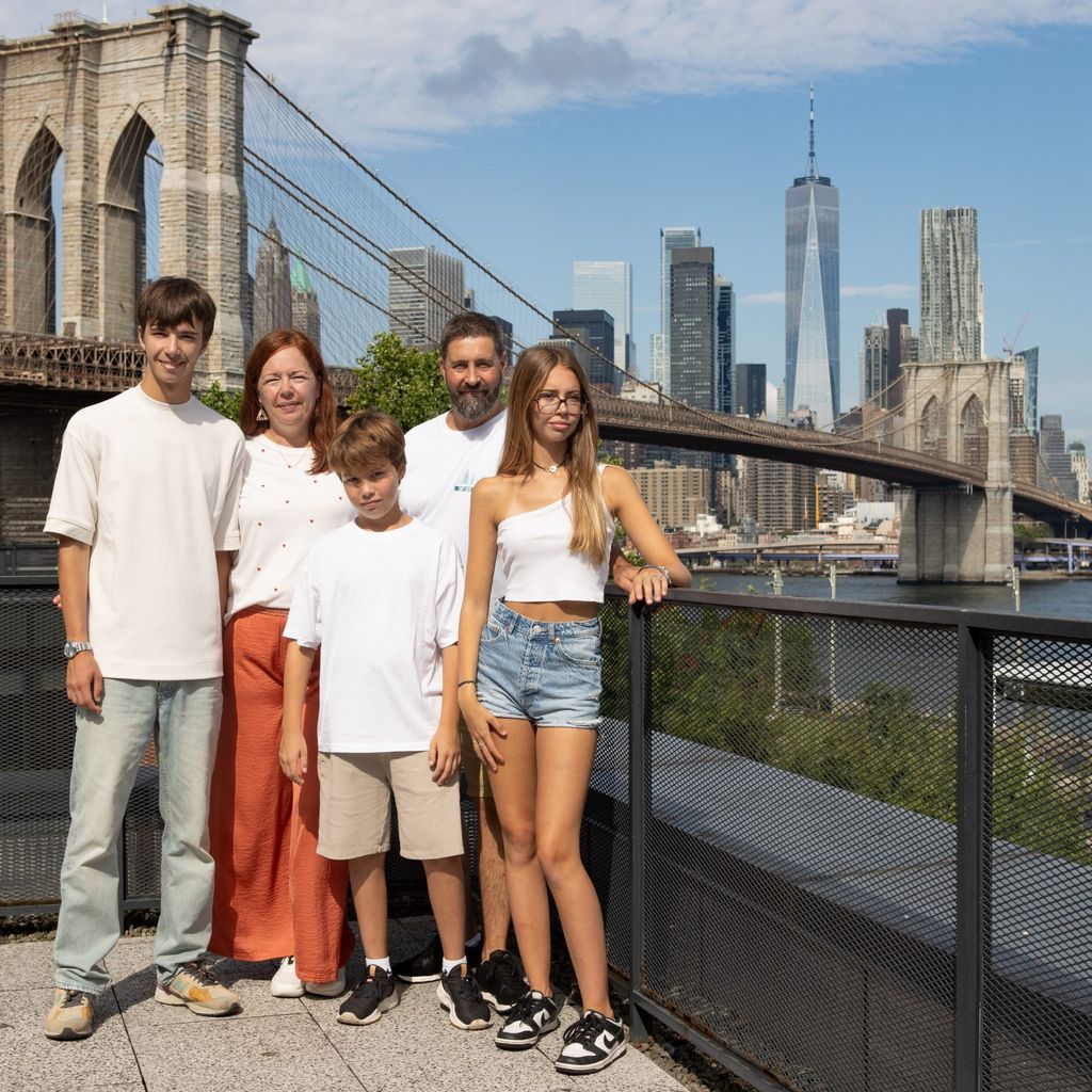 Famille posant pour une photo devant la skyline de Manhattan et le pont de Brooklyn