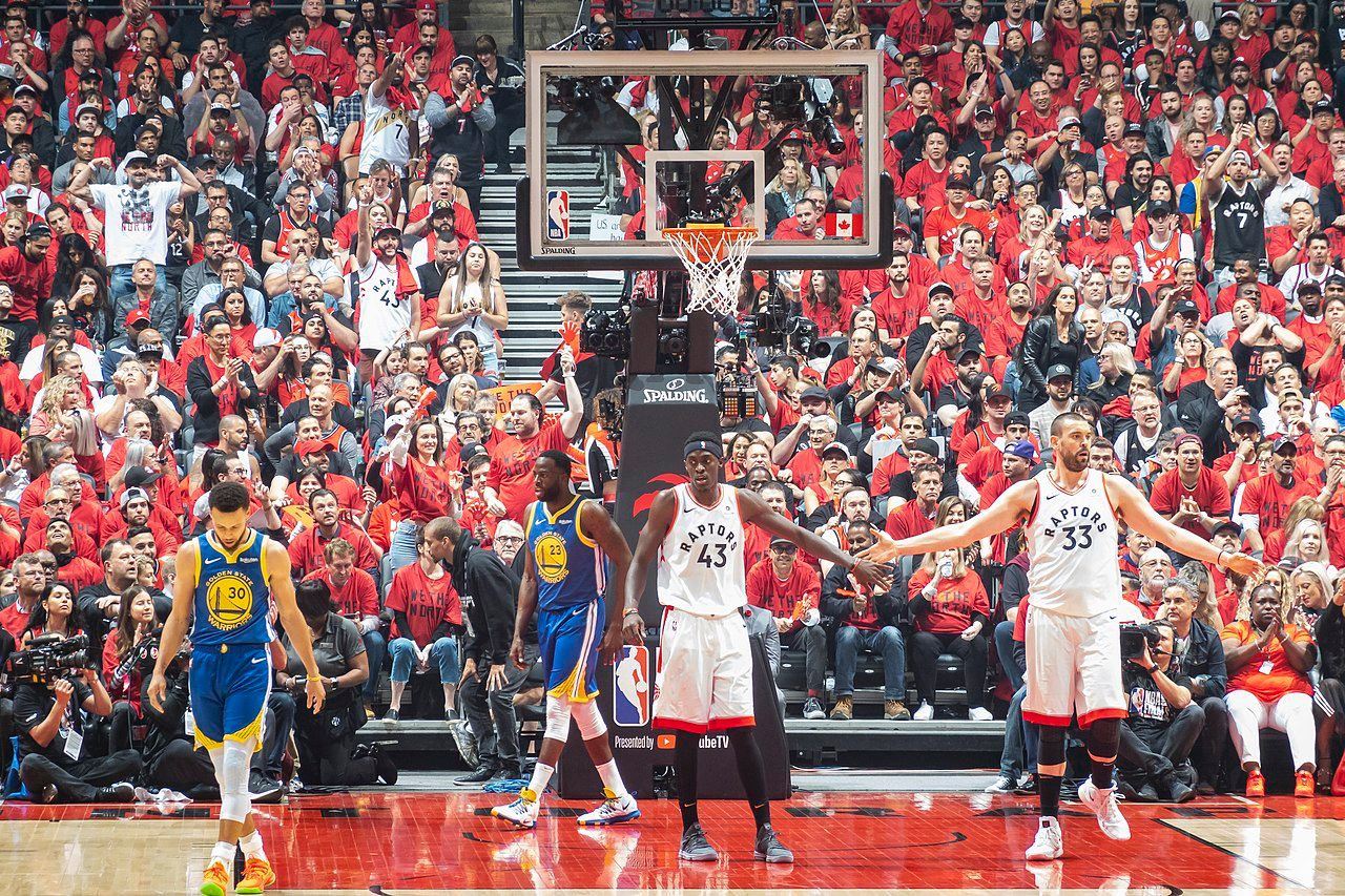 Joueurs des équipes de NBA des Golden State Warriors et des Toronto Raptors sur le terrain