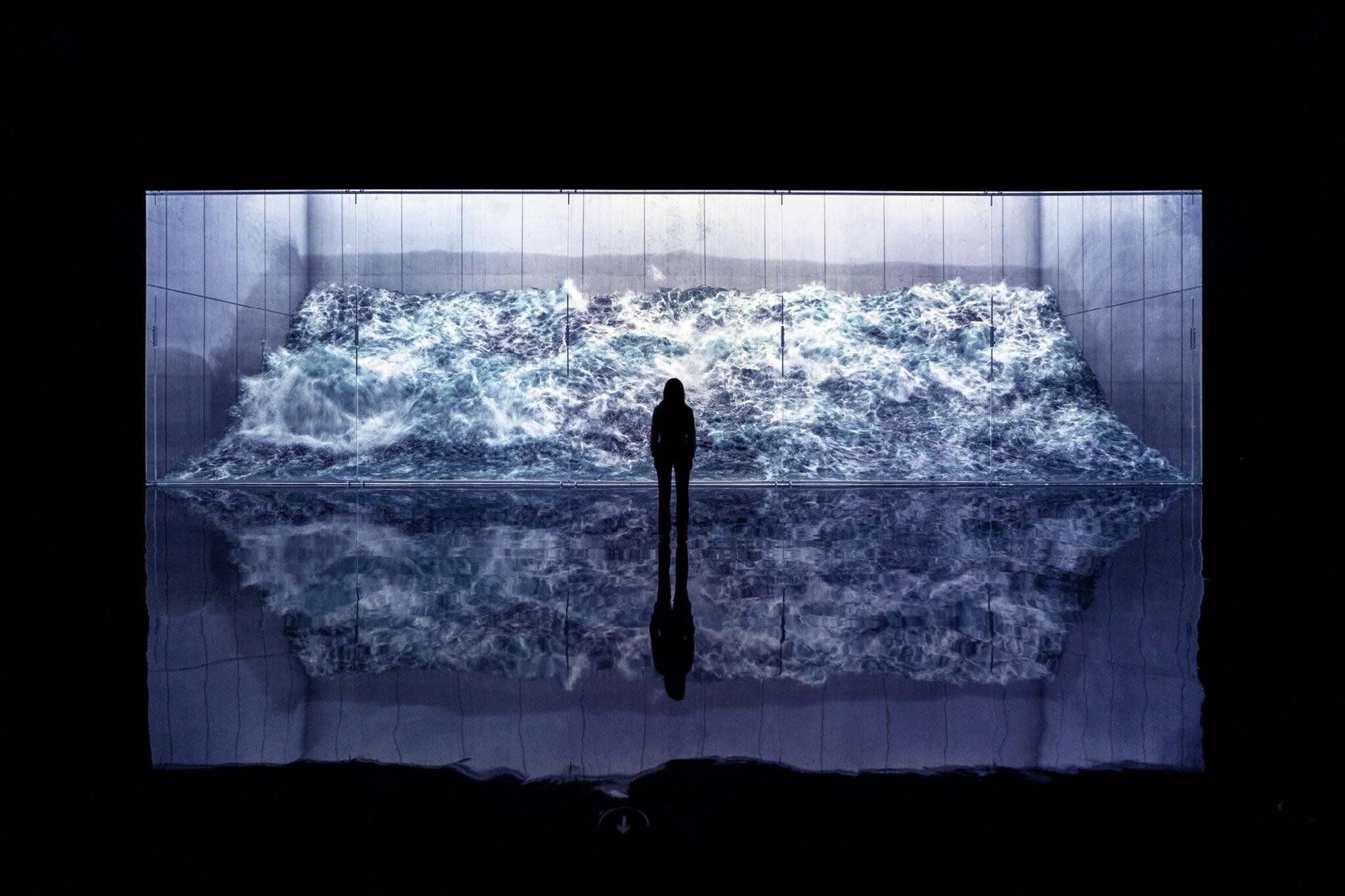 Jeune femme devant une œuvre d'art représentant une vague au Arte Museum de New York