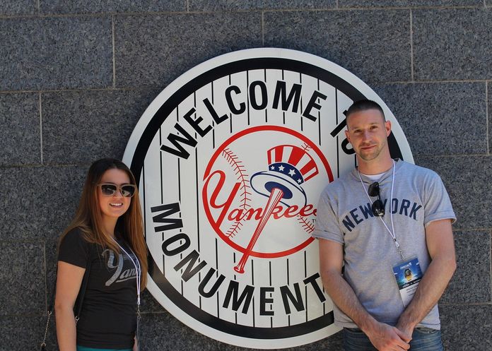Couple posant devant le logo des New York Yankees au Yankee Stadium
