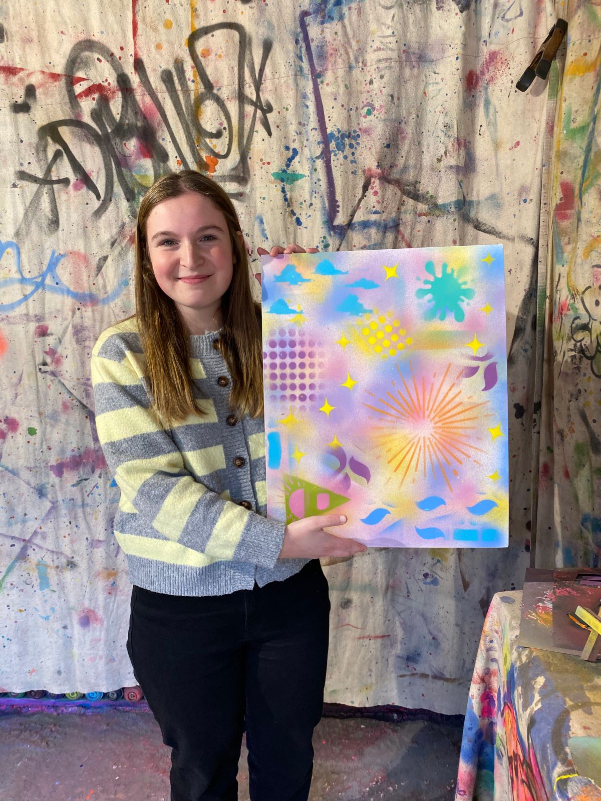 Jeune fille posant avec un tableau réalisé à New York