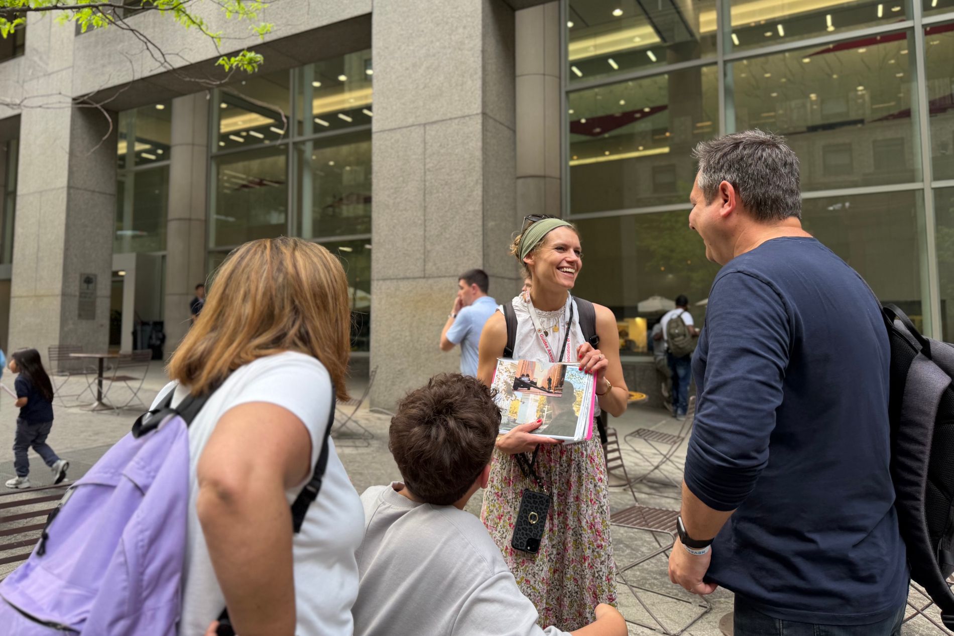 Guide montrant des photos de films à des touristes dans une rue de New York