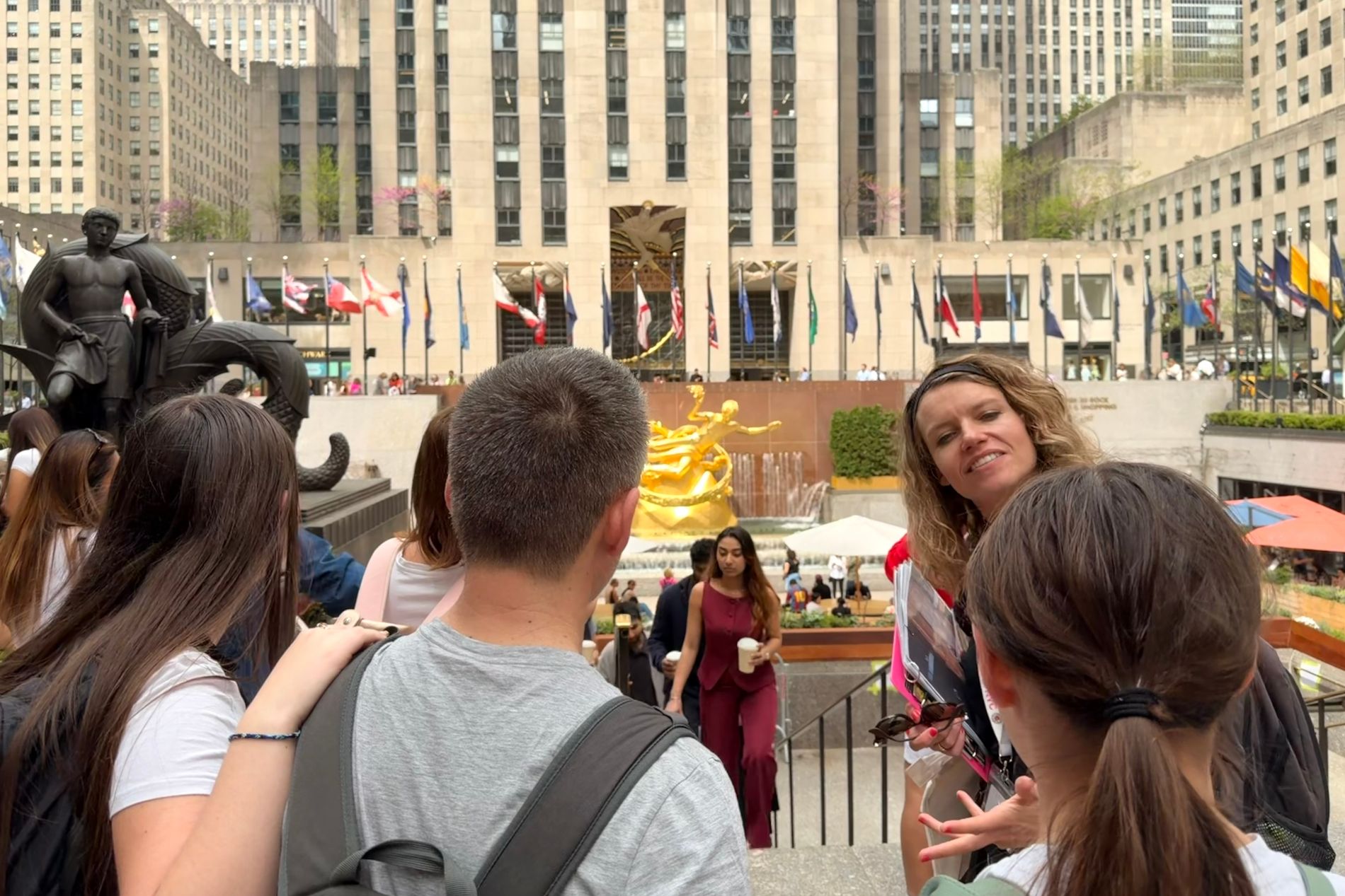 Guide touristique avec des touristes devant le Rockefeller Center à New York