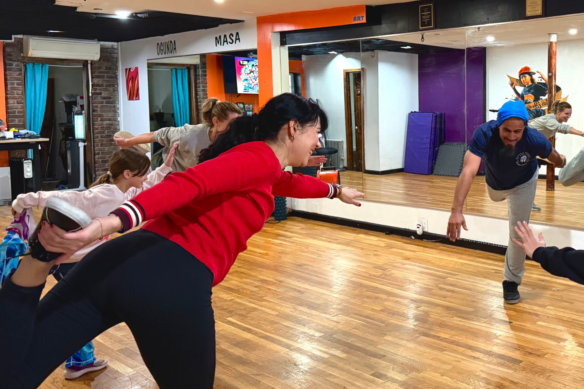 Touristes faisant des mouvements lors d'un cours de breakdance à New York