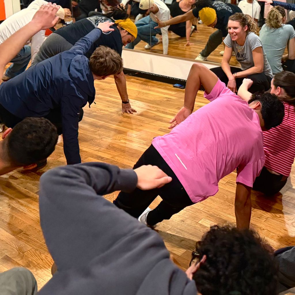 Touristes faisant des mouvements lors d'un cours de breakdance à New York