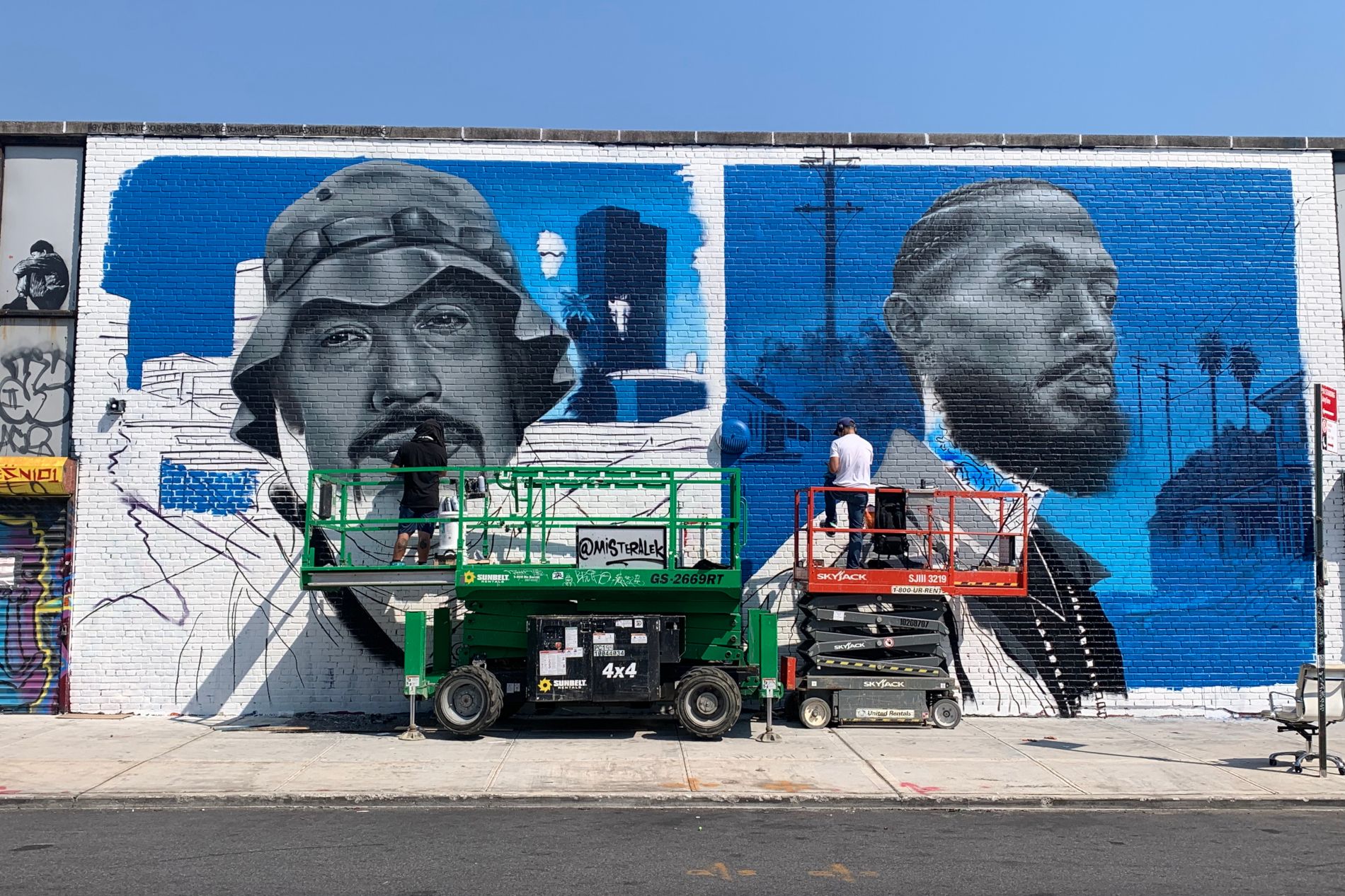 artistes en train de réaliser une fresque de street art dans le quartier de Bushwick à New York