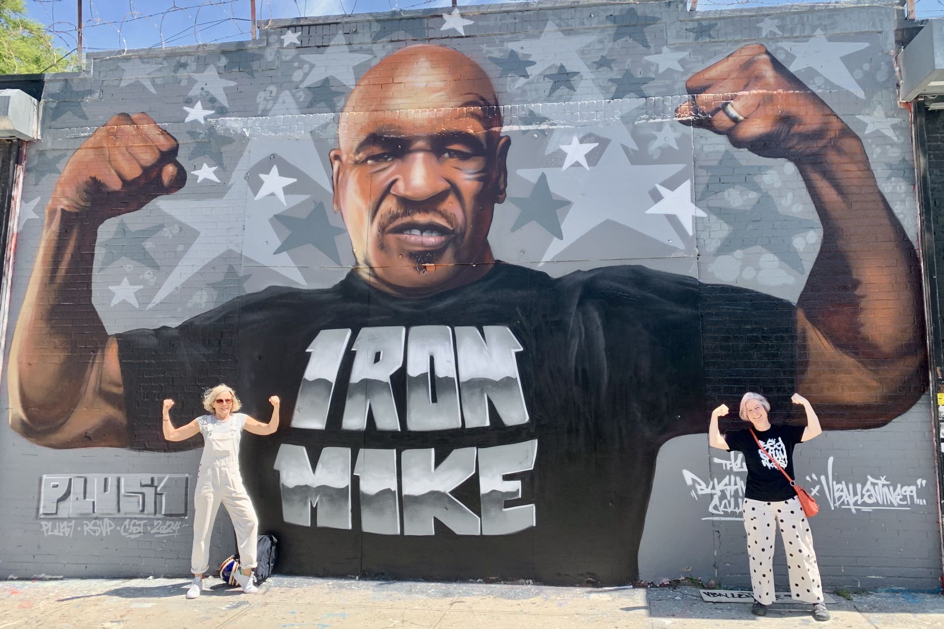 Femmes posant une fresque représentant le boxeur Mike Tyson à New York