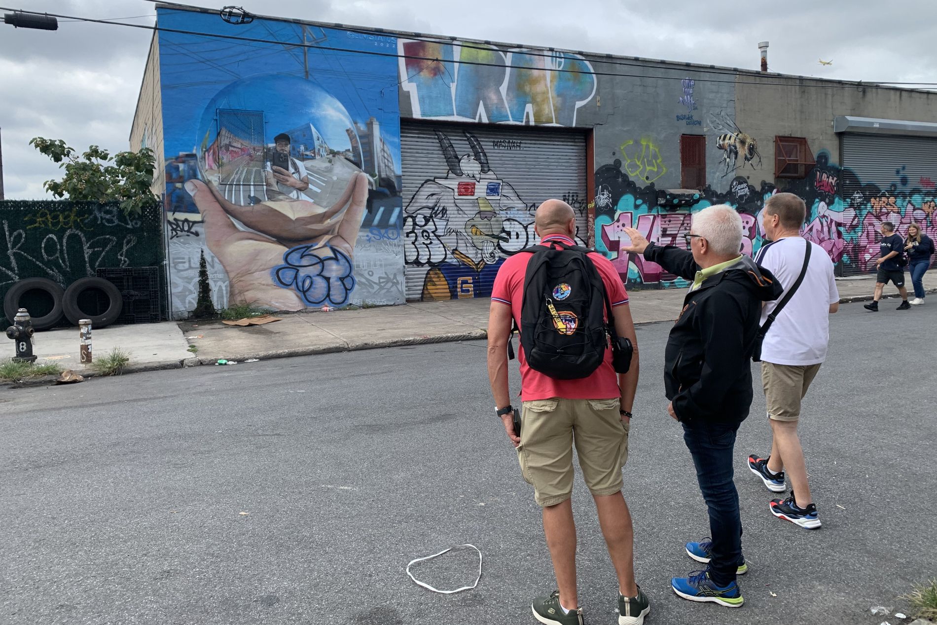 Touristes admirant une fresques de street art dans le quartier de Bushwick.